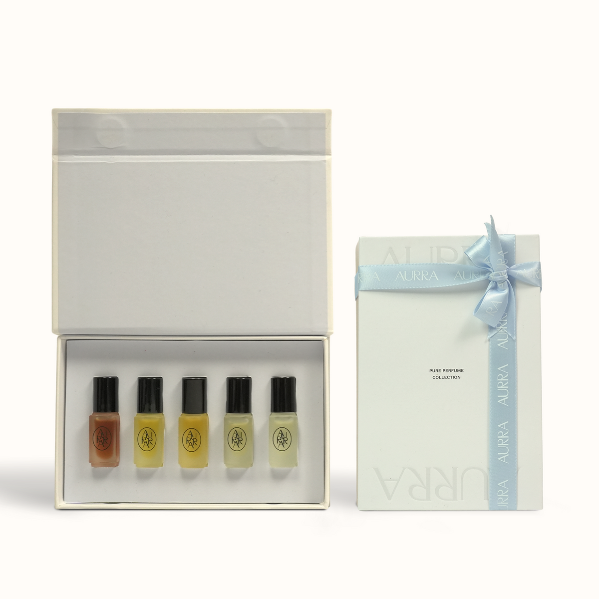 A boxed fragrance gift set on a clean white background, showing an open white box with five perfume sample vials and a matching closed box with a pale blue ribbon and bow. The visible text includes AURRA.
