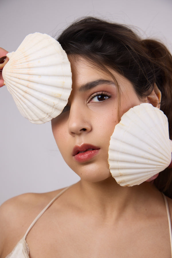 Woman holding seashells on a gray background